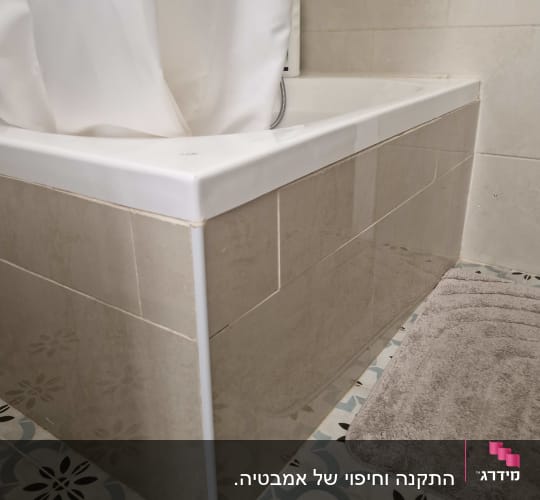 אמבטיה עם וילון לבן ורצפת אריחים מעוצבת